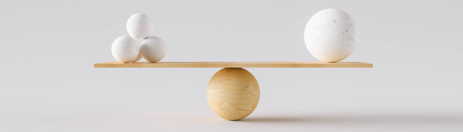 Balance en bois en équilibre avec des sphères blanches, retour à l’essentiel