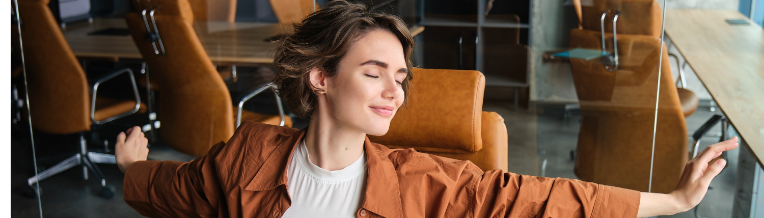 Femme s’étirant sereinement à son bureau, réconcilier corps et esprit au travail